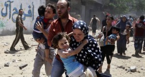 Palestinians run following what police said was an Israeli air strike on a house in Gaza