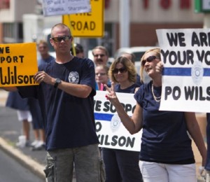 Supporters of officer Darren Wilson hold placards outside Barney's Sports Pub in St. Louis, Missouri