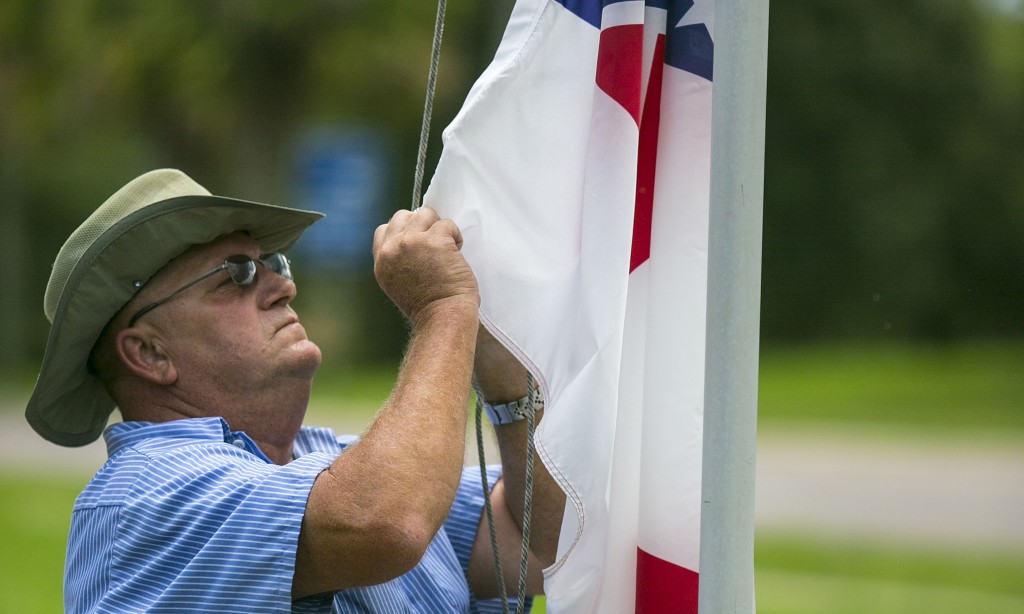 Marion County maintenance worker Vic Pollock adjusts the Confederate flag on the flag pole outside the McPherson Governmental Complex in Ocala, Fla., on Tuesday, July 7, 2015. The Marion County Commission voted Tuesday to put the flag back up after taking it down recently. (Alan Youngblood/Ocala Star-Banner via AP) MANDATORY CREDIT MAGS OUT