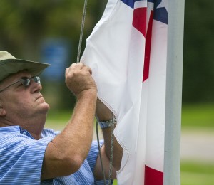 Marion County maintenance worker Vic Pollock adjusts the Confederate flag on the flag pole outside the McPherson Governmental Complex in Ocala, Fla., on Tuesday, July 7, 2015. The Marion County Commission voted Tuesday to put the flag back up after taking it down recently. (Alan Youngblood/Ocala Star-Banner via AP) MANDATORY CREDIT MAGS OUT